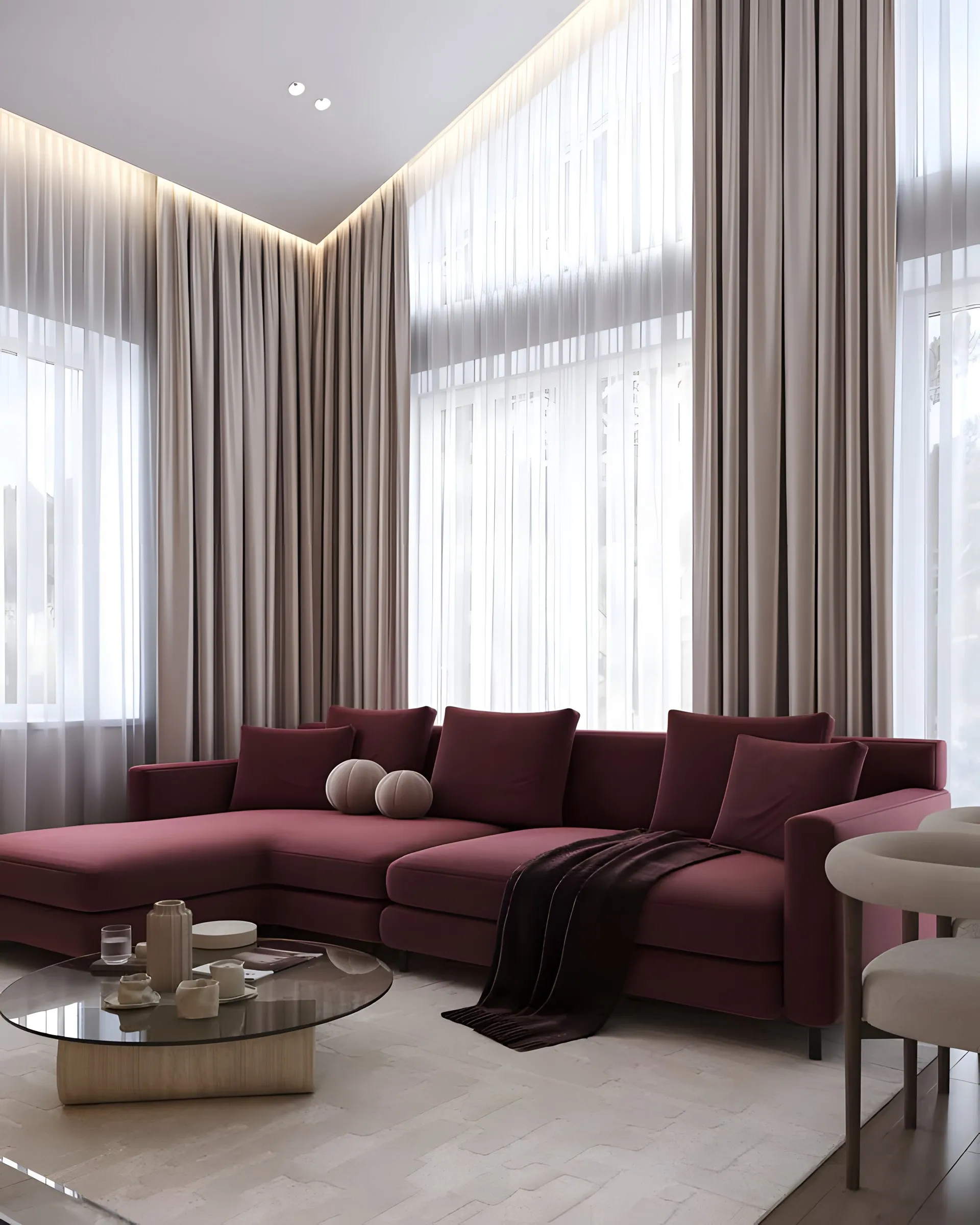 Cortinas hoteleras beige y visillo a doble altura en sala con sofá burdeos, Homes Punta Cana